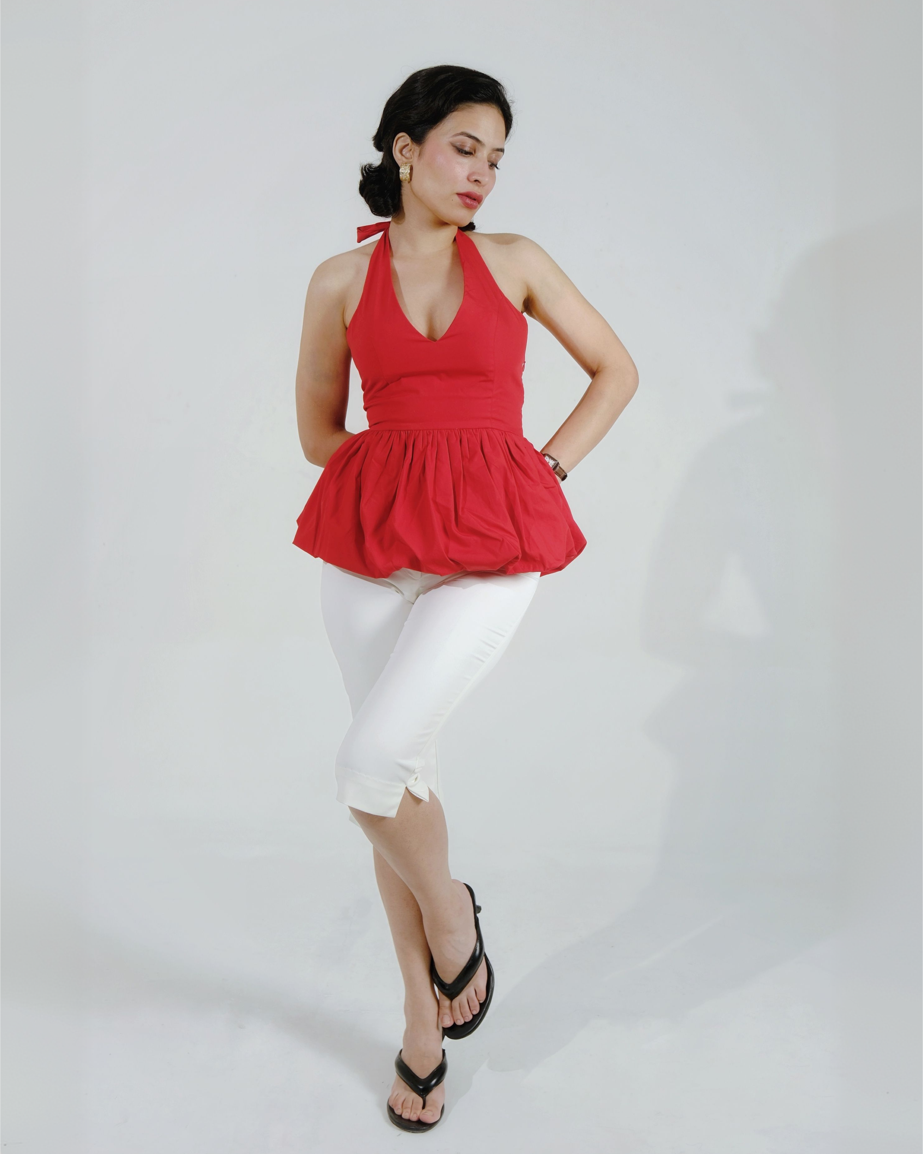 Red halter neck peplum top with deep plunging neckline, worn with white pants