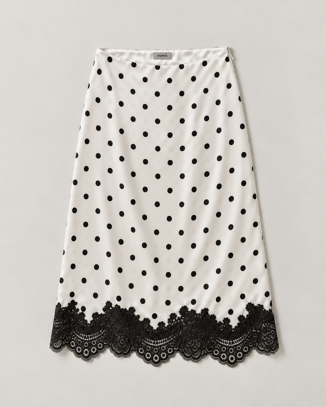 A white A-line skirt with black polka dots and a black lace hem, displayed flat against a light gray background.