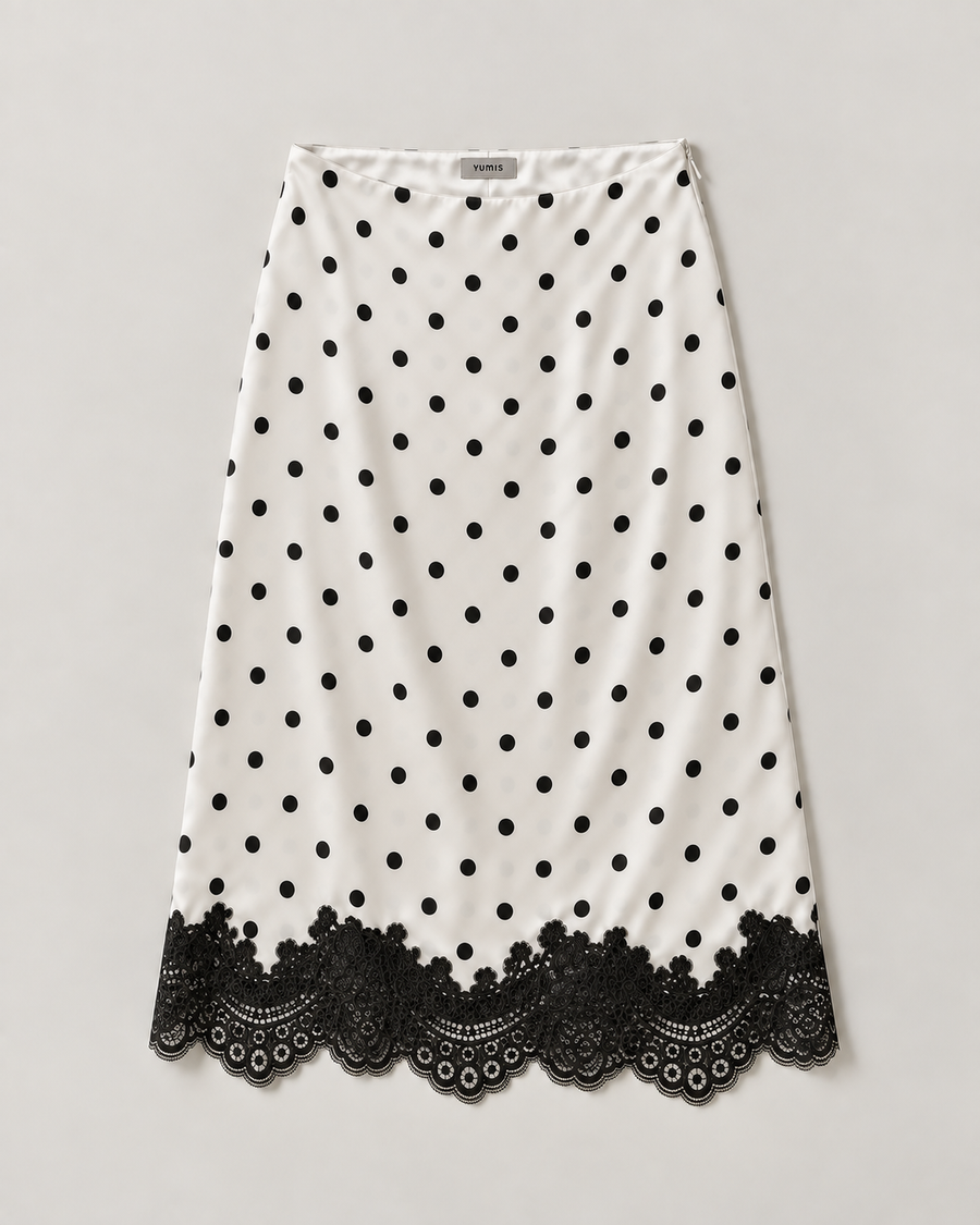 A white A-line skirt with black polka dots and a black lace hem, displayed flat against a light gray background.